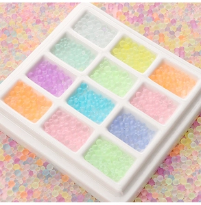 Macro detail of multi-color matte frosted glass beads in a 12-slot storage box