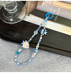 Detail of blue and white beaded phone strap with cute hand-painted tropical fish charms