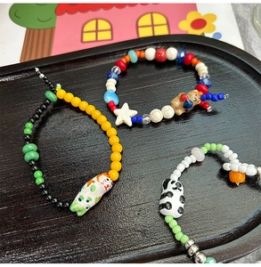 Detailed view of handmade ceramic bead bracelets with cute cat bear and panda charms