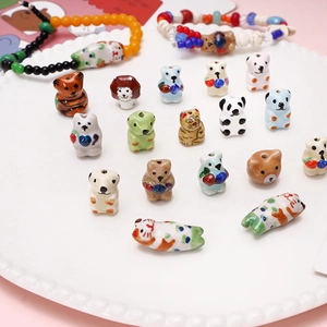 Handmade ceramic animal beads and finished DIY bracelets in a white porcelain dish