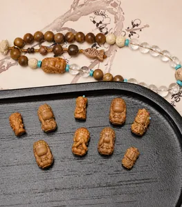 Detailed view of hand-carved miniature wooden Buddha figures and mixed gemstone beads