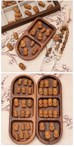 Detailed macro view of intricately carved wooden Buddha beads and miniature monk sculptures