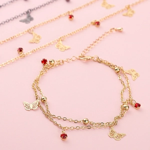 Bracciale a farfalla dorato con strass rossi e design a catena a doppio strato