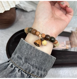 Bracelet artisanal en bois de jujubier avec pendentif lotus porté au poignet