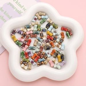 Hand-painted ceramic bone-shaped beads for DIY jewelry making in a white star tray
