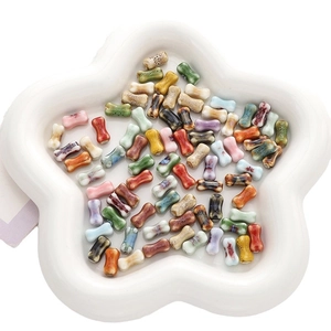 Colorful bone-shaped ceramic beads in a star dish for DIY bracelet and necklace making