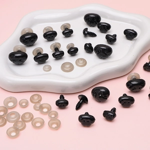 Assortiment zwarte acryl poppenneuzen en ogen met schroefdraad op roze dienblad