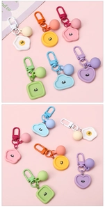 Macro detail of macaron resin keychains with smiling faces and matte colorful finish