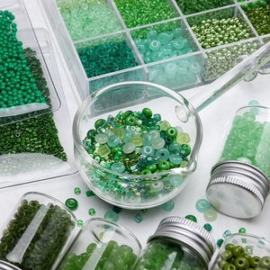DIY green glass seed beads set in organizer box and glass jars for jewelry making