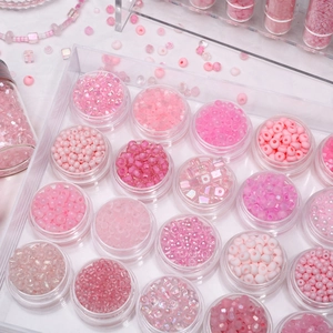 Pink DIY bead kit with various textures in clear bottles on an acrylic tray
