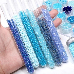 Macro view of blue glass seed beads in glass test tubes for DIY jewelry making