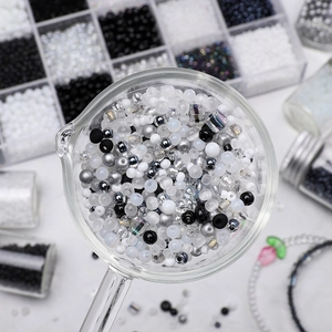 DIY jewelry kit with dark glass seed beads in a glass scoop for handmade accessories
