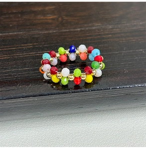 Gros plan d'une bague faite main en perles de verre facettées 3mm avec détails dorés
