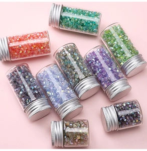 Makroaufnahme bunter 4mm Aurora-Bicone-Kristallperlen in kleinen Glasflaschen mit Silberkappe