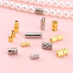 Gold and silver screw clasps for DIY jewelry making displayed on a pink background