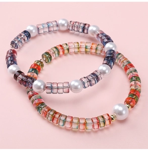 Close-up of colorful square glass beads and white imitation pearls for DIY bracelets
