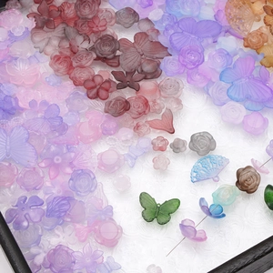 Mix of colorful frosted acrylic jewelry beads with floral and butterfly shapes for DIY crafts