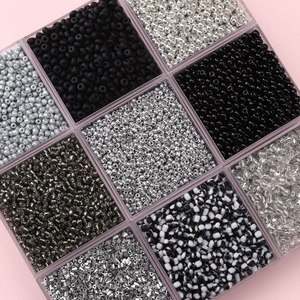 DIY jewelry making kit featuring dark grey and black glass seed beads in a grid box