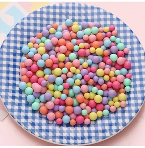 Macro-opname van kleurrijke macaron acryl kralen op een blauw geblokt bord voor hobby