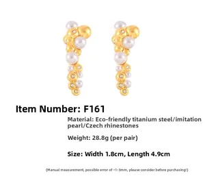 Detail view of gold titanium earrings with stacked irregular pearls and crystal diamonds