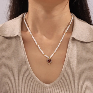 Elegant pearl choker necklace with heart-shaped red zircon pendant on gold-plated chain