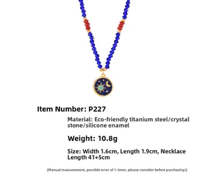 Dettaglio del ciondolo in smalto blu con sole e luna su collana di perle di cristallo