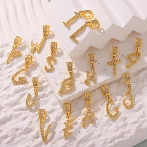 Ciondolo a lettera chic placcato oro 18k con zirconi su sfondo di gradini bianchi