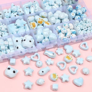 Blue ceramic beads set in heart and star shapes for DIY jewelry making in a plastic box