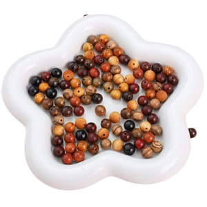 Polished assorted natural wood beads in a white floral tray for DIY jewelry making