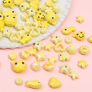 Assorted yellow ceramic cartoon beads in fish, cat and heart shapes for DIY jewelry making