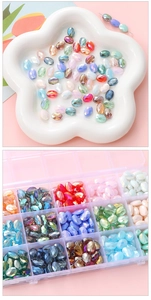 Macro detail of multi-colored faceted oval crystal beads in a floral dish and storage box