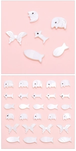 Macro shot of white shell animal charms including butterfly and fox for DIY jewelry making