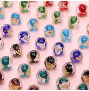 Macro shot of colorful 10mm glass beads with gold foil and central holes for jewelry making