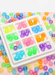 Close-up of colorful luminous acrylic barrel beads in a 12-slot storage organizer box