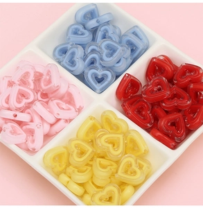 Gros plan de perles acryliques en forme de cœur en quatre couleurs pour bijoux DIY