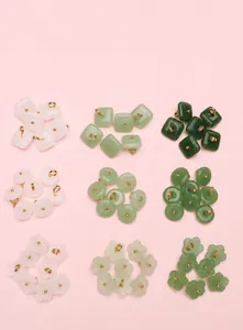 Macro detail of lily of the valley faux jade glass charms in three colors and shapes
