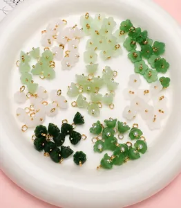 Detail of Lily of the Valley flower charms in green and white on a ceramic plate