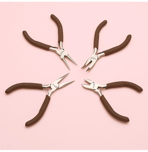 Macro shot of 4-piece jewelry pliers set with brown grips on a pink background