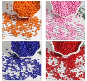 Detailopname van 2-4mm glazen kralen in oranje, roze, blauw en rood voor DIY-sieraden