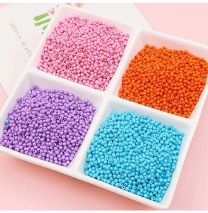 Vue de dessus de perles en acrylique 3mm roses, oranges, violettes et bleues en plateau