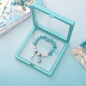 Dettaglio del bracciale oceanico con perline a stella e ciondolo delfino nella scatola