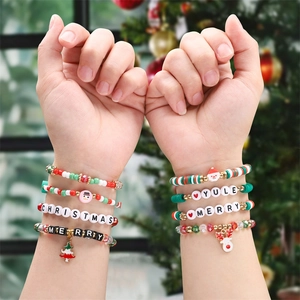 Close-up of Christmas beaded bracelets featuring festive charms and letter beads on wrist