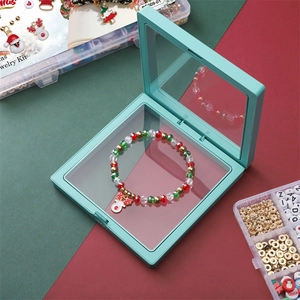 Close-up of Christmas DIY jewelry kit with reindeer charm bracelet in a green storage box