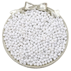 Vue détaillée de perles rondes blanches pour bijoux DIY sur un plateau de présentation argent