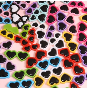 Vue macro de mini lunettes en acrylique colorées en forme de cœur pour bricolage poupée