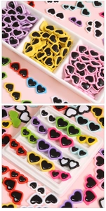 Gros plan de mini lunettes colorées en acrylique en forme de cœur pour accessoires de poupée