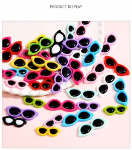 Close-up of colorful mini acrylic round sunglasses for DIY dolls and crafts on a tray