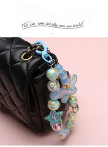 Detailed view of a colorful beaded keychain with a blue carabiner on a black bag