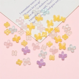 Cuentas de resina con forma de flor de cuatro pétalos para bisutería en un fondo pastel suave