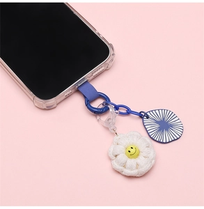 Detail of candy-colored phone lanyard with blue chain and knitted flower charm
